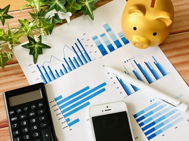 デスク上の経済資料と電卓
