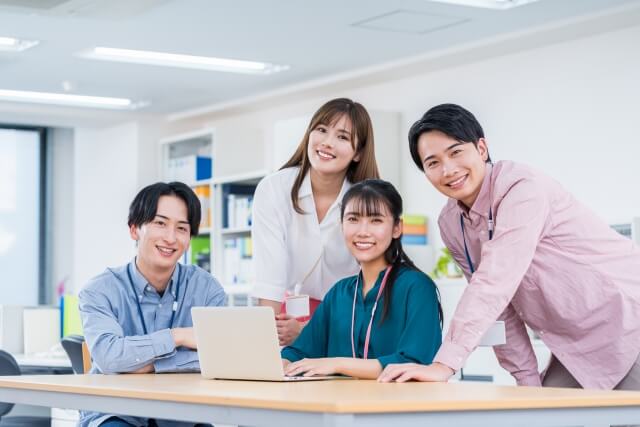 オフィスで協力する四人の同僚