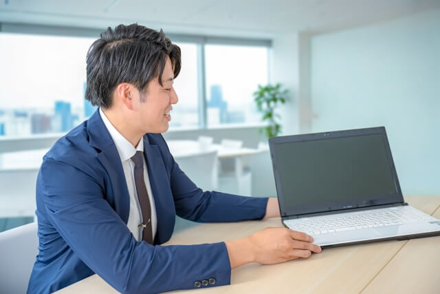 オフィスでノートパソコンを指す男性