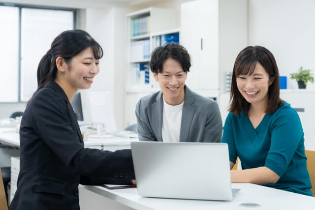 会議中の議論を進める三人の同僚